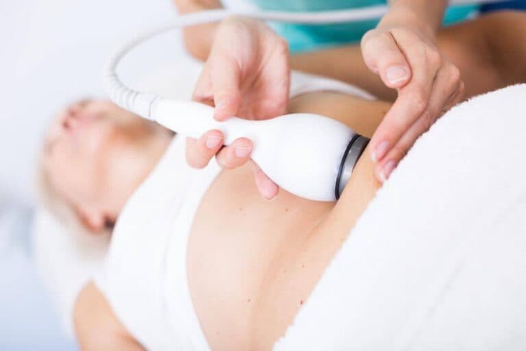 A body contouring handpiece being used on a client's abdomen